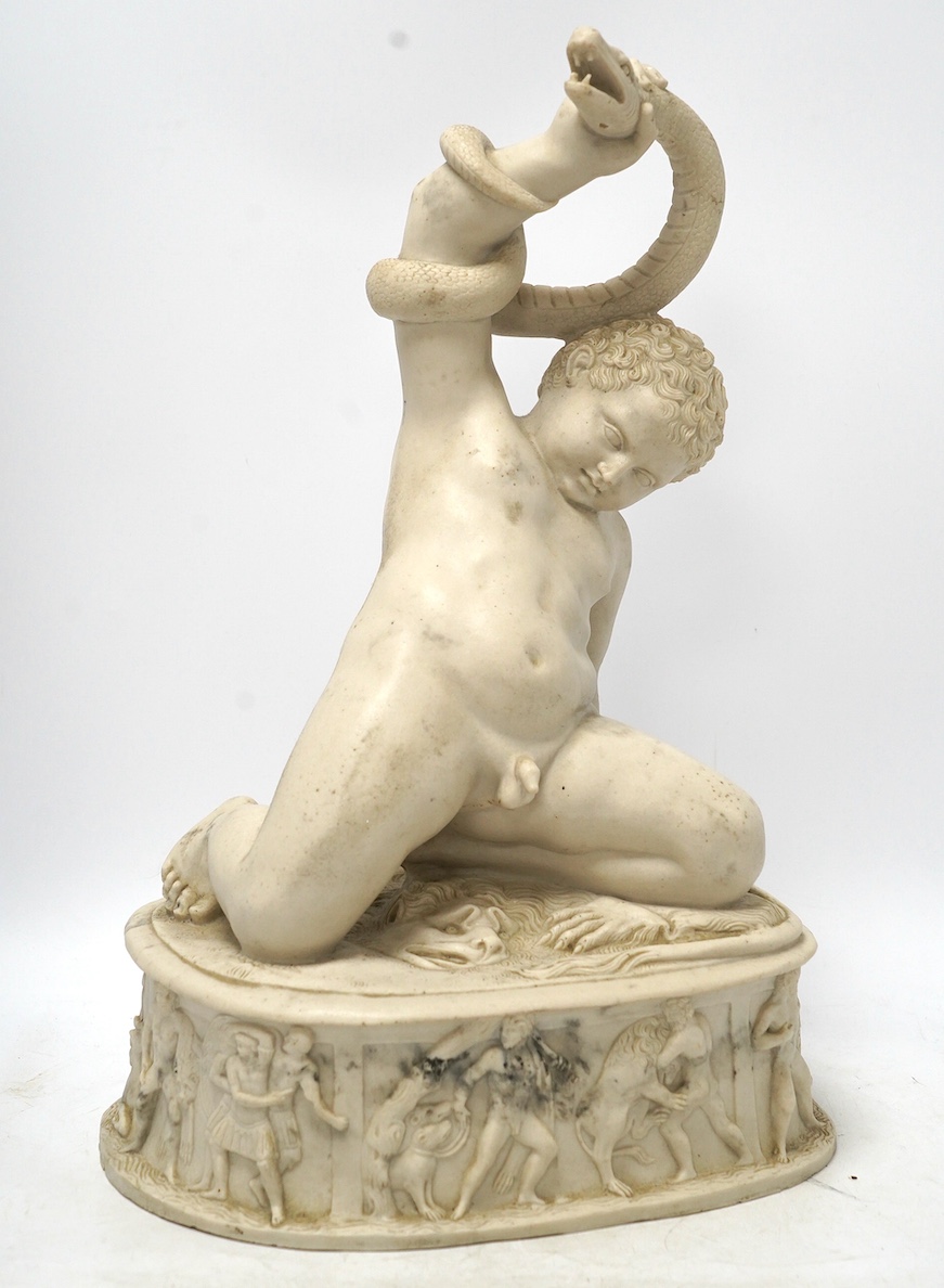 A decorative resin figure of a boy wrestling serpents, 46cm high. Condition - good
